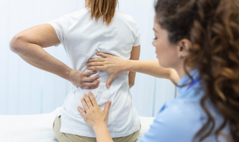 Paciente recibiendo una evaluación médica por dolor lumbar y posible lesión de la médula espinal durante una consulta especializada.