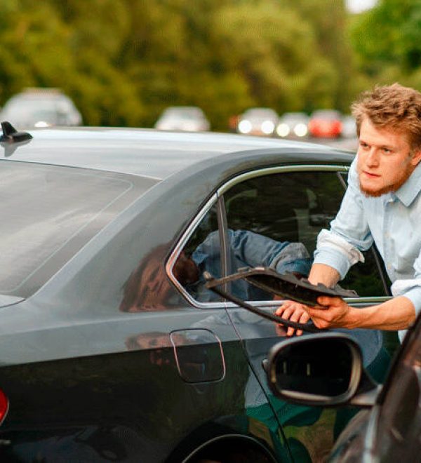 Distressed woman and a man arguing beside their damaged cars after a roadside accident.