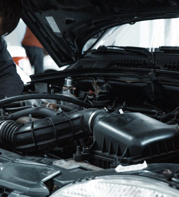 Mecánico certificado inspeccionando el motor de un carro durante una inspección vehicular en Texas