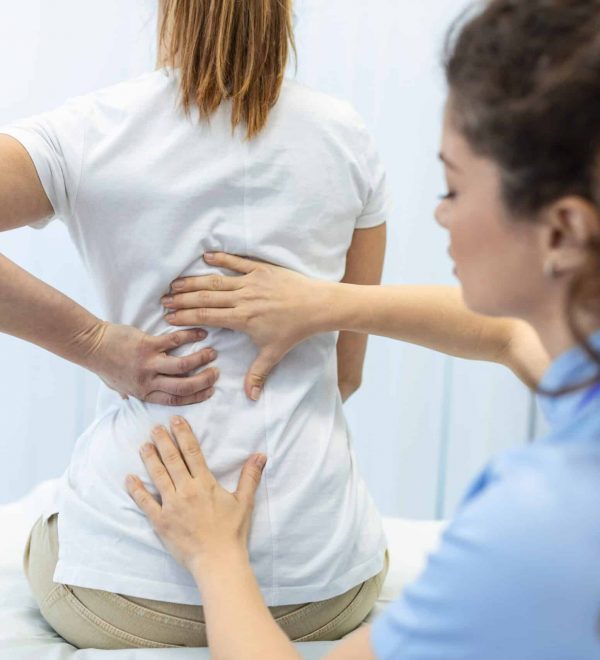 Paciente recibiendo una evaluación médica por dolor lumbar y posible lesión de la médula espinal durante una consulta especializada.
